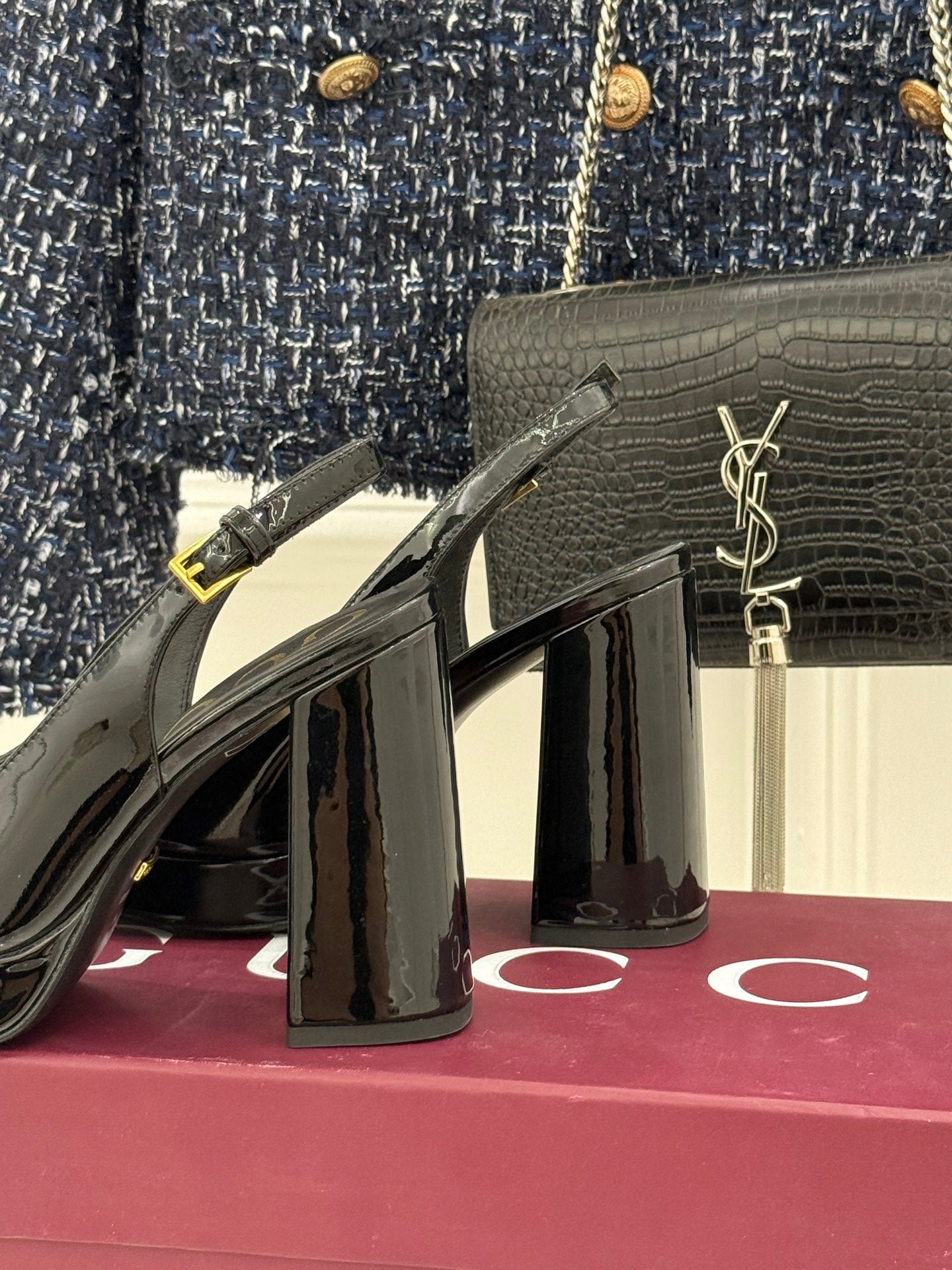 Gucci black patent heeled shoes featuring gold horsebit detail and tall glossy heel
