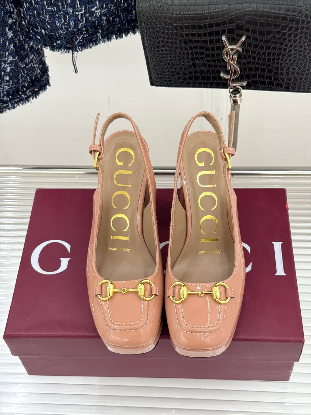 Light pink slingback pumps with gold horsebit detail and thick heel
