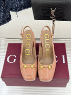 Light pink slingback pumps with gold horsebit detail and thick heel