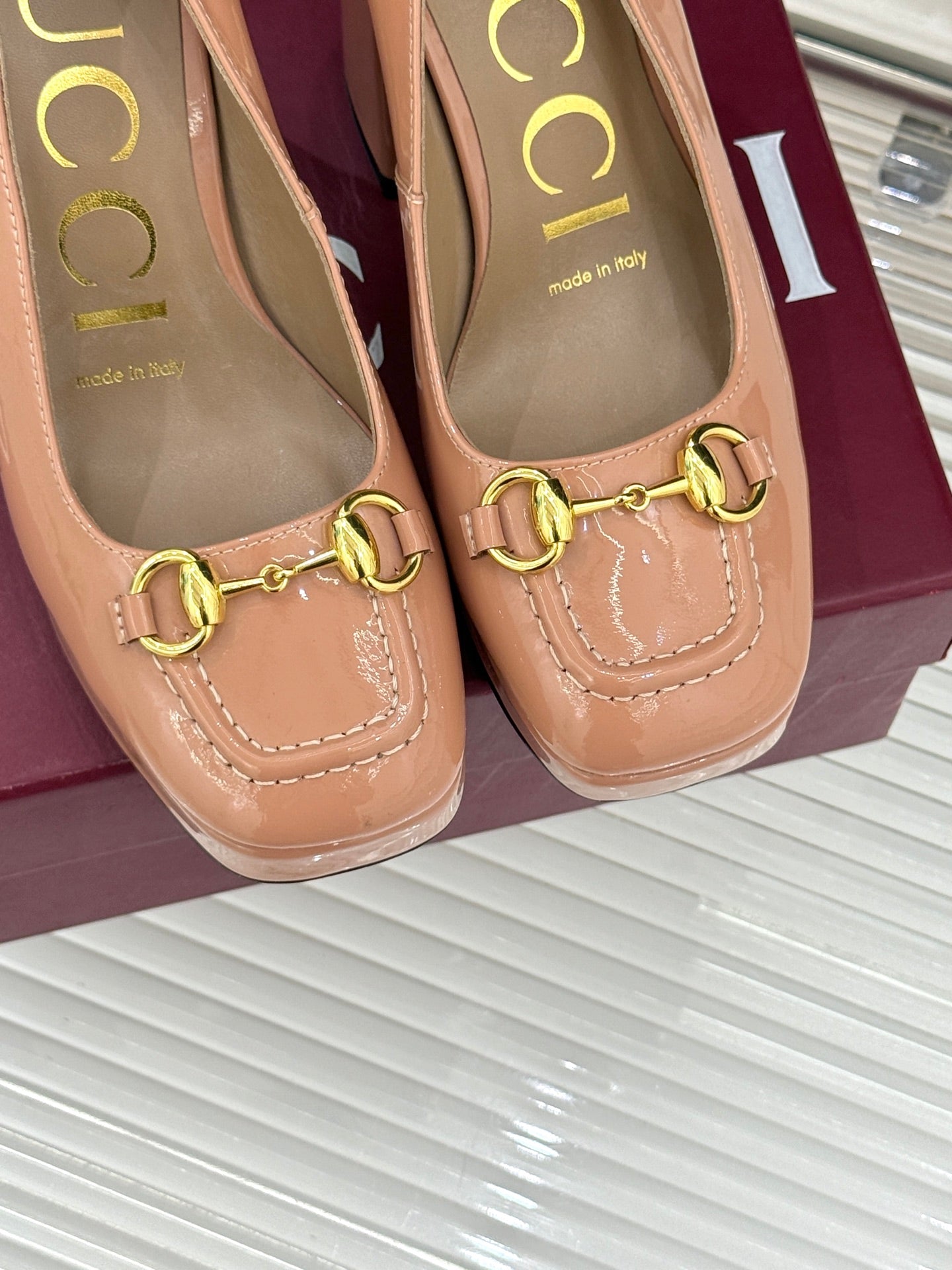 Gucci peach pumps close-up with gold horsebit detail and stitched moc-style seam