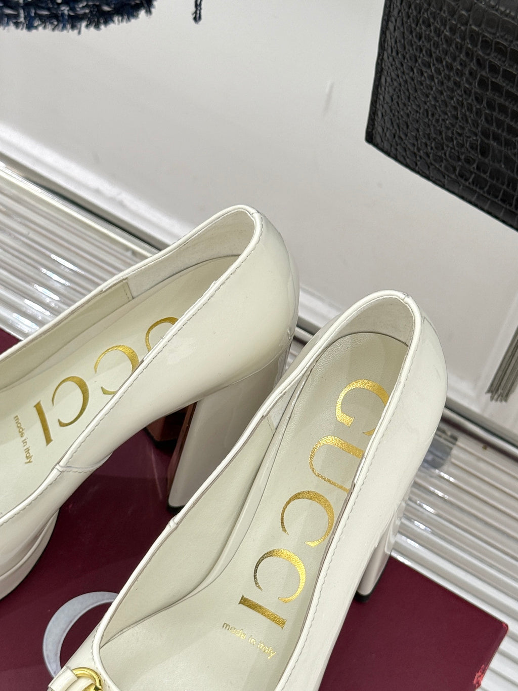 Gucci white leather loafer heels with gold horsebit, angled side view