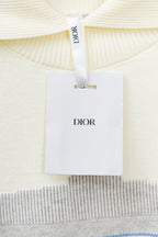Cream sweater collar with white Dior tag attached to neckline