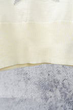 Cream ribbed sweater chest panel with subtle texture and curved knit detail