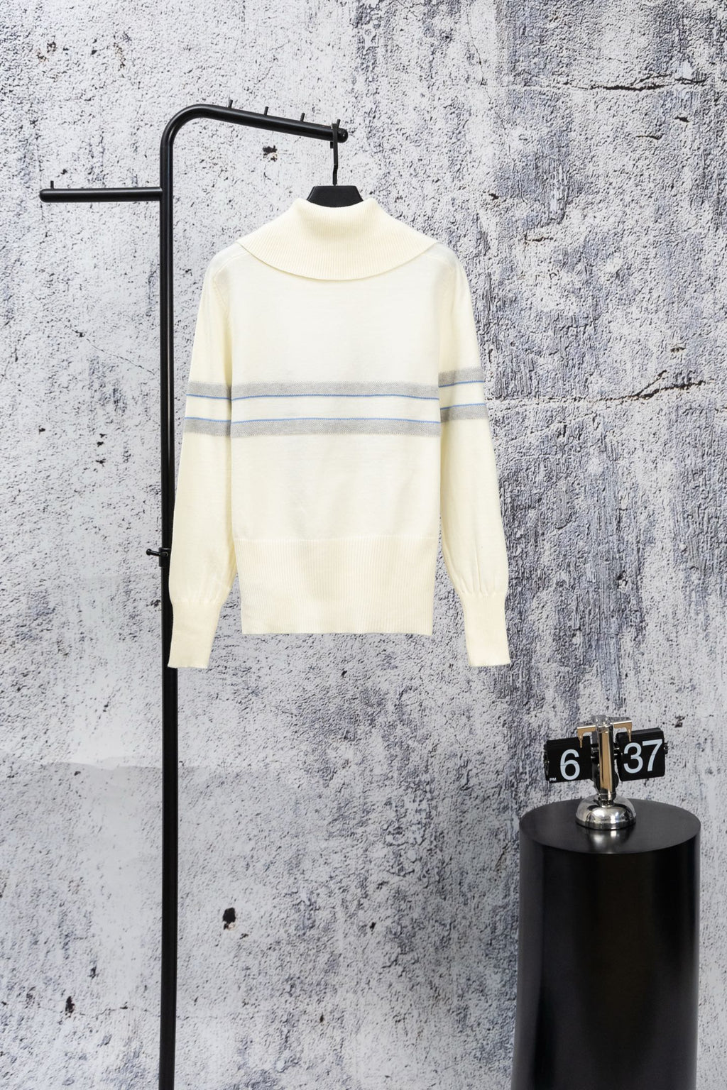 Cream long-sleeve sweater with high neck and blue stripe bands, minimal logo detail