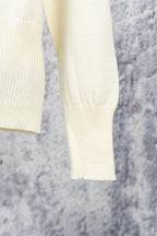 Cream sweater sleeves and hem with ribbed cuffs and soft knit texture