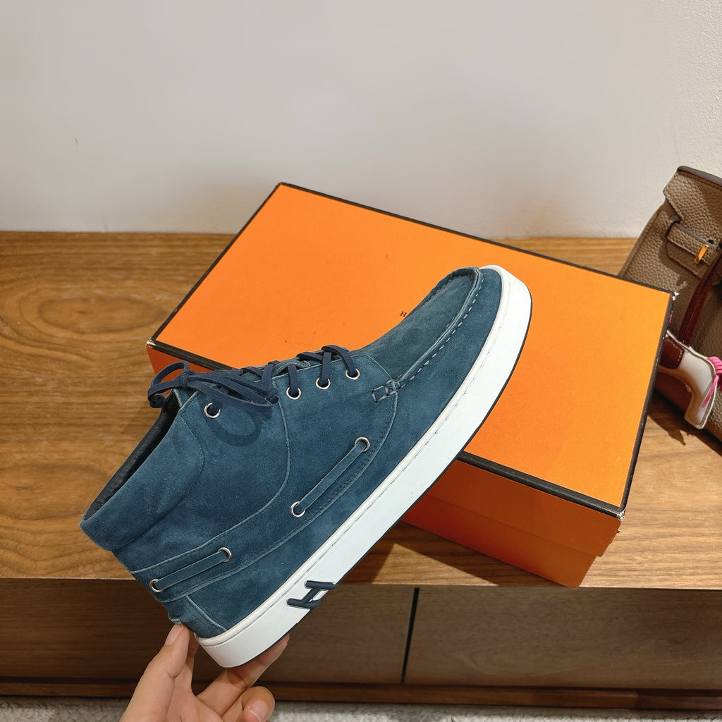 Unisex blue suede lace-up shoe held up, white sole with stitched seam detail