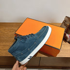 Unisex blue suede lace-up shoe held up, white sole with stitched seam detail