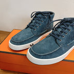 Unisex blue suede lace-up shoes close-up: white soles and dark lace eyelets