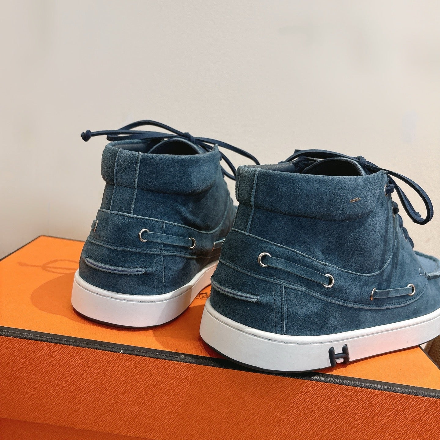 Unisex blue suede lace-up shoes heel view with white soles and rear stitching