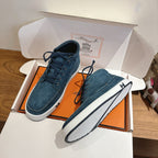 Unisex blue suede lace-up shoes with white soles, dark laces, and stitched panels