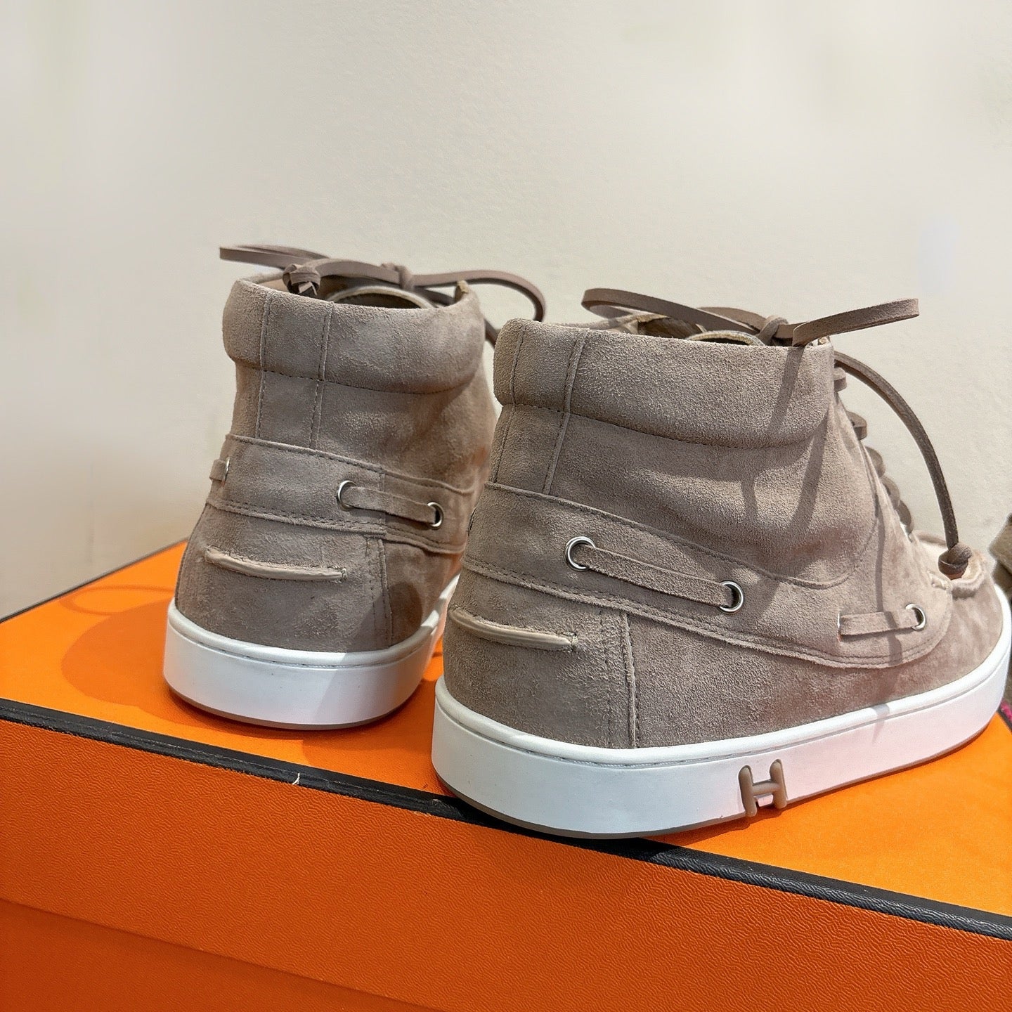 Hermes unisex gray suede high-top sneakers, heel view with lace-up and white sole.