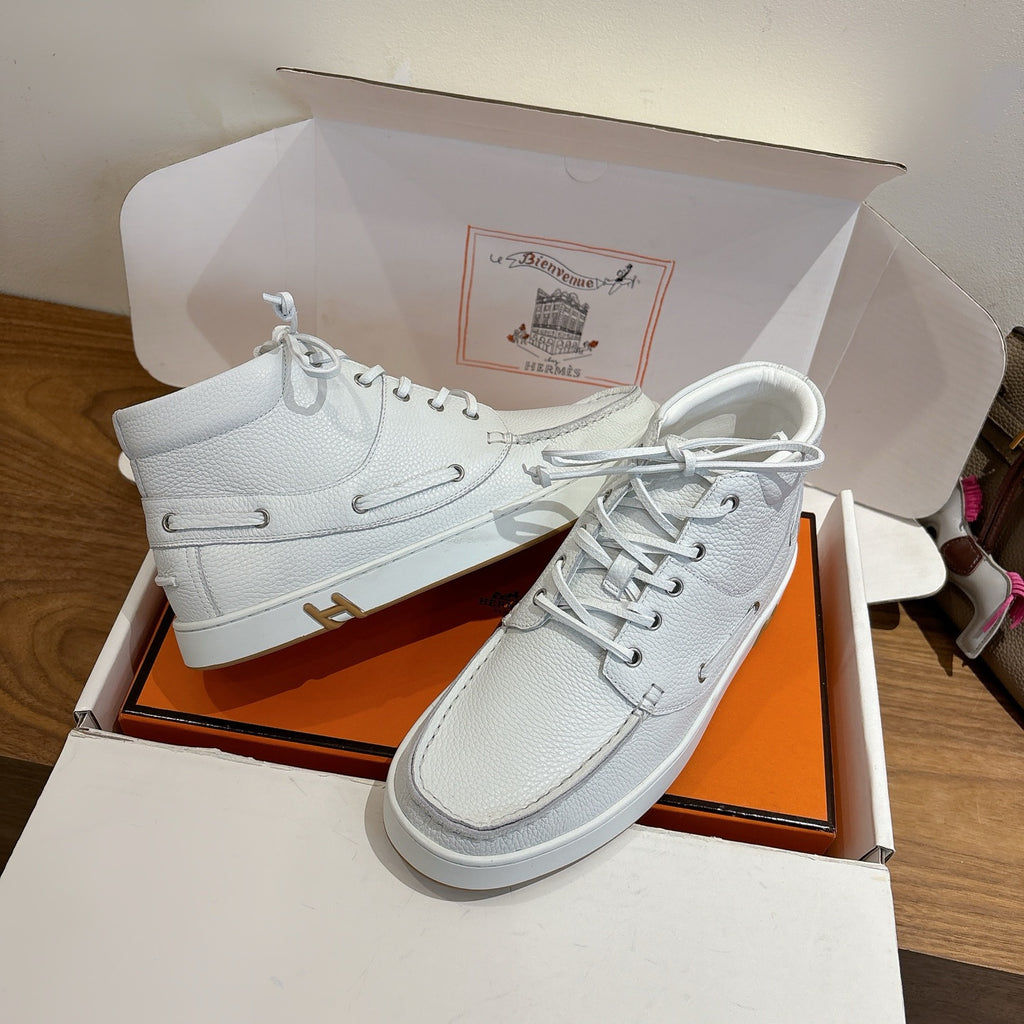 White high-top sneakers with lace-up closure, gold H emblem on side