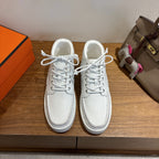 White low-top sneakers, lace-up leather, gold H detail on side