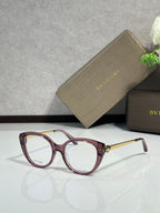 Burgundy oversized round glasses with clear lenses and gold-tone hinges