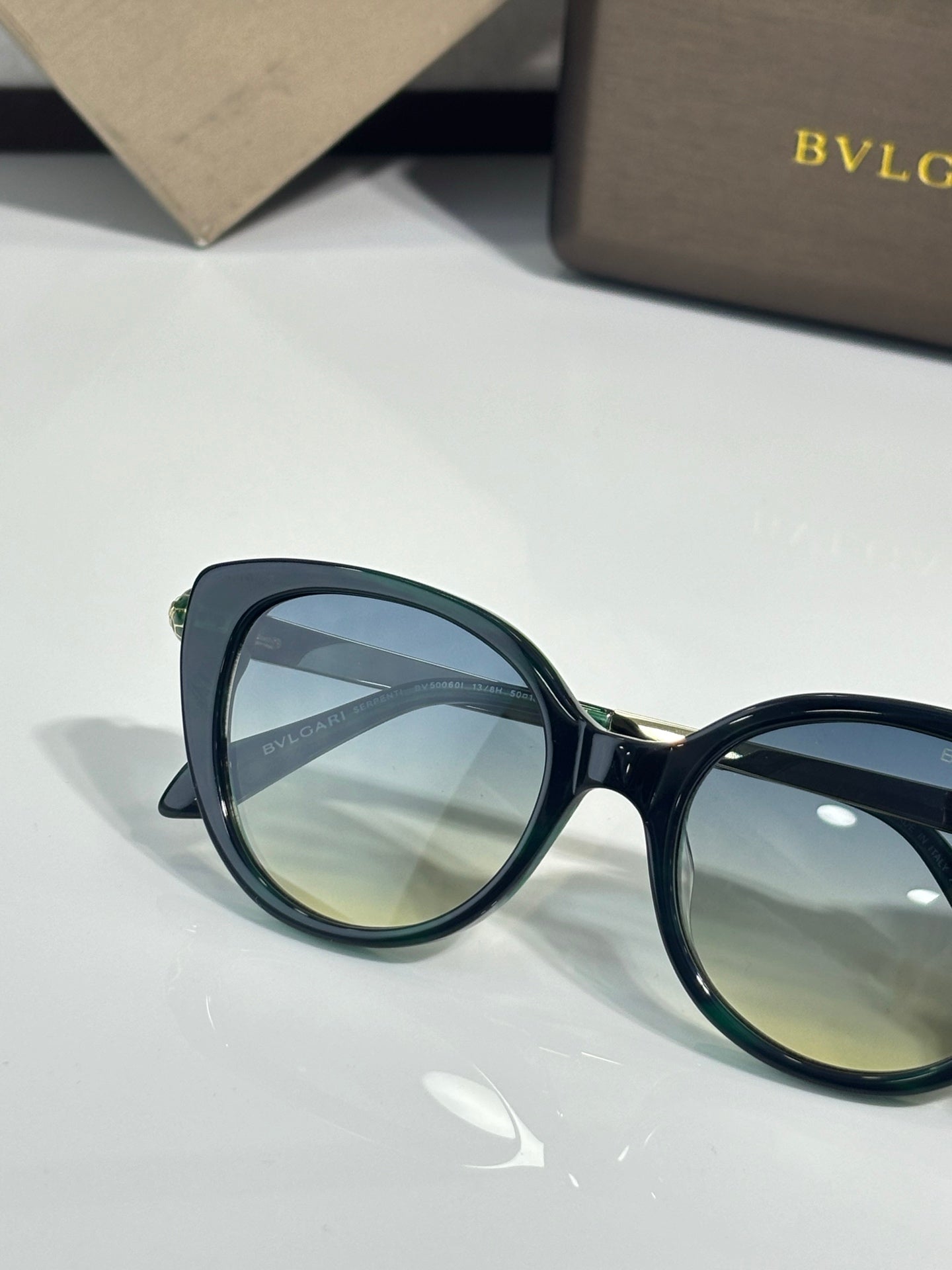 Black round eyeglasses with tinted lenses and gold-tone hinge details