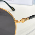 Gucci glasses close-up: gold-tone rim and dark lens with hinged metal temple