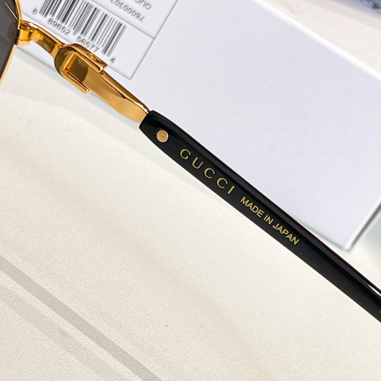 Gucci glasses close-up: black temple with gold lettering and “MADE IN JAPAN”
