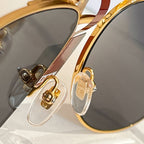 Gucci glasses close-up: gold-tone frame detail and dark lenses with decorative temple accents