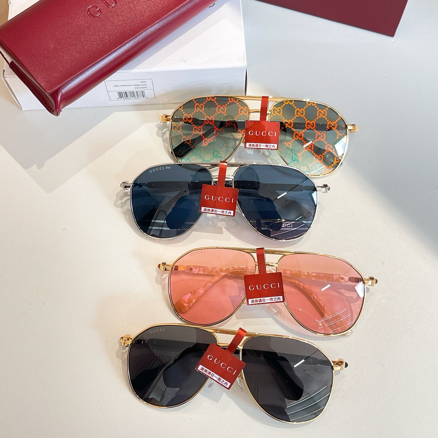 Gucci glasses stacked: monogram blue pair, pink pair, and dark pair with gold frames
