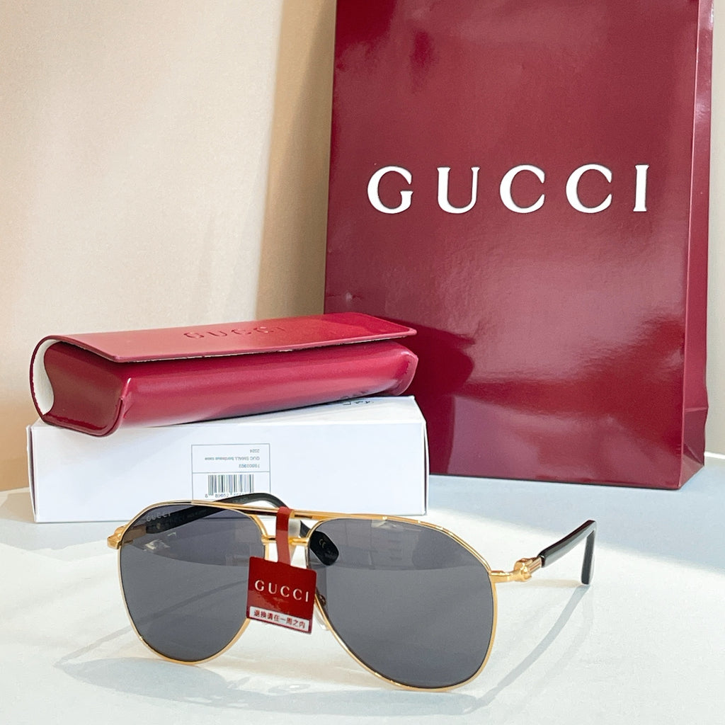 Gucci glasses with gold-tone frames and dark gray mirrored lenses, with metal temples