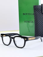Bottega Veneta eyeglasses with black frames and gold textured temples.