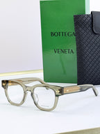 Bottega Veneta eyeglasses with light beige frames and gold textured temples.