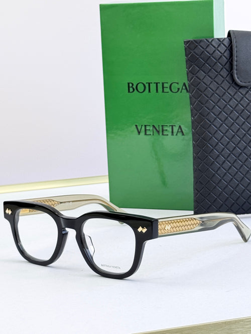 Bottega Veneta eyeglasses with black frames and gold patterned side arms.