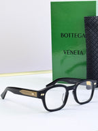 Black eyeglasses with round frames and gold patterned temple detail