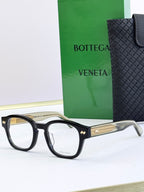 Black eyeglasses with round frames and gold patterned temple insets