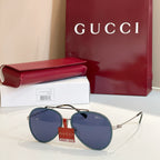 Gucci round sunglasses with blue-tinted lenses and gold-tone metal frame.