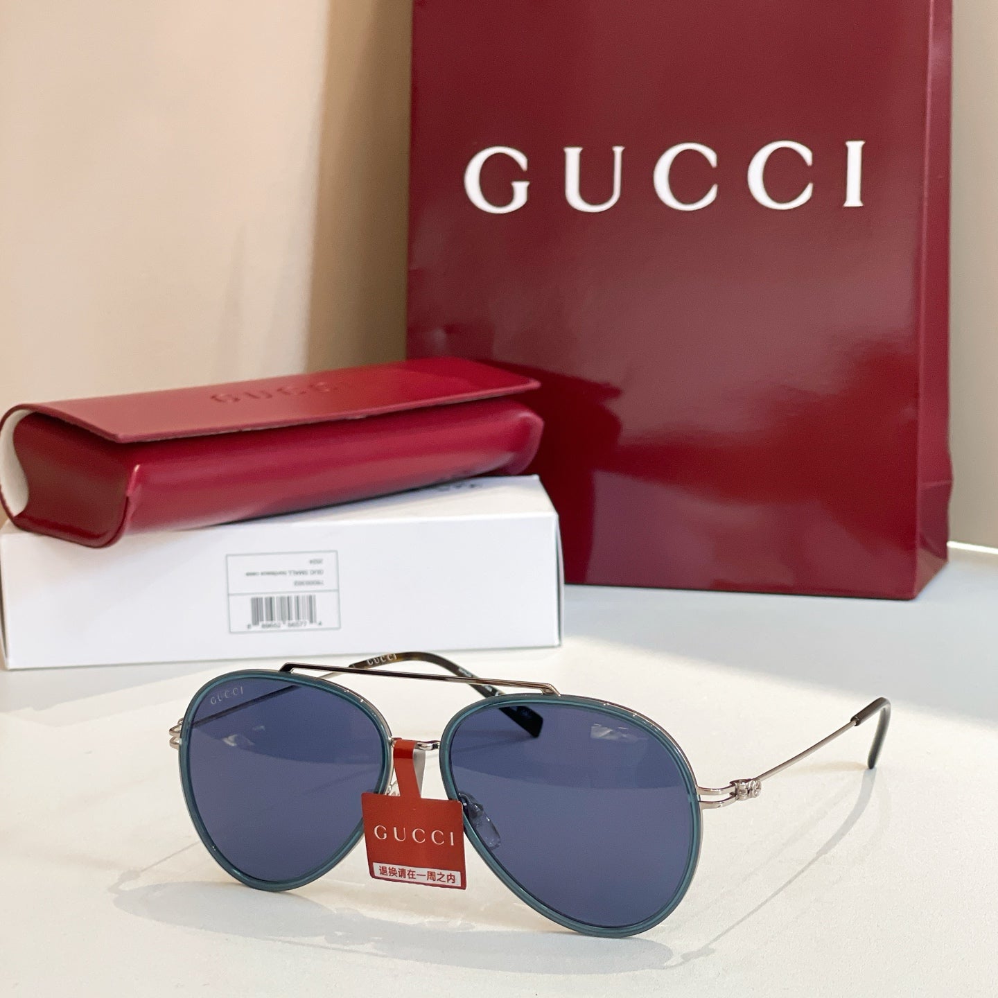 Gucci round sunglasses with blue-tinted lenses and gold-tone metal frame.