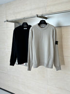 Light gray knit sweater on hanger with ribbed crew neck and cuffs