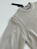 Light gray knit sweater sleeve with shoulder seam and ribbed neckline