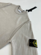Light gray knit sweater with ribbed crew neck and side logo patch