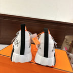 Hermes unisex sneakers back view, white knit with orange trim and black heel pull tabs