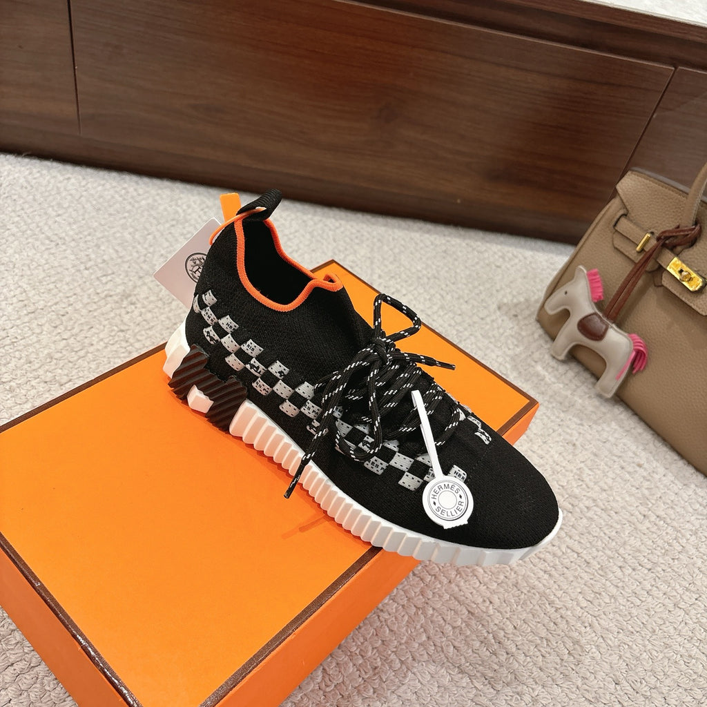 Hermes unisex sneaker: black knit with orange trim, white checker stripe, white tread sole