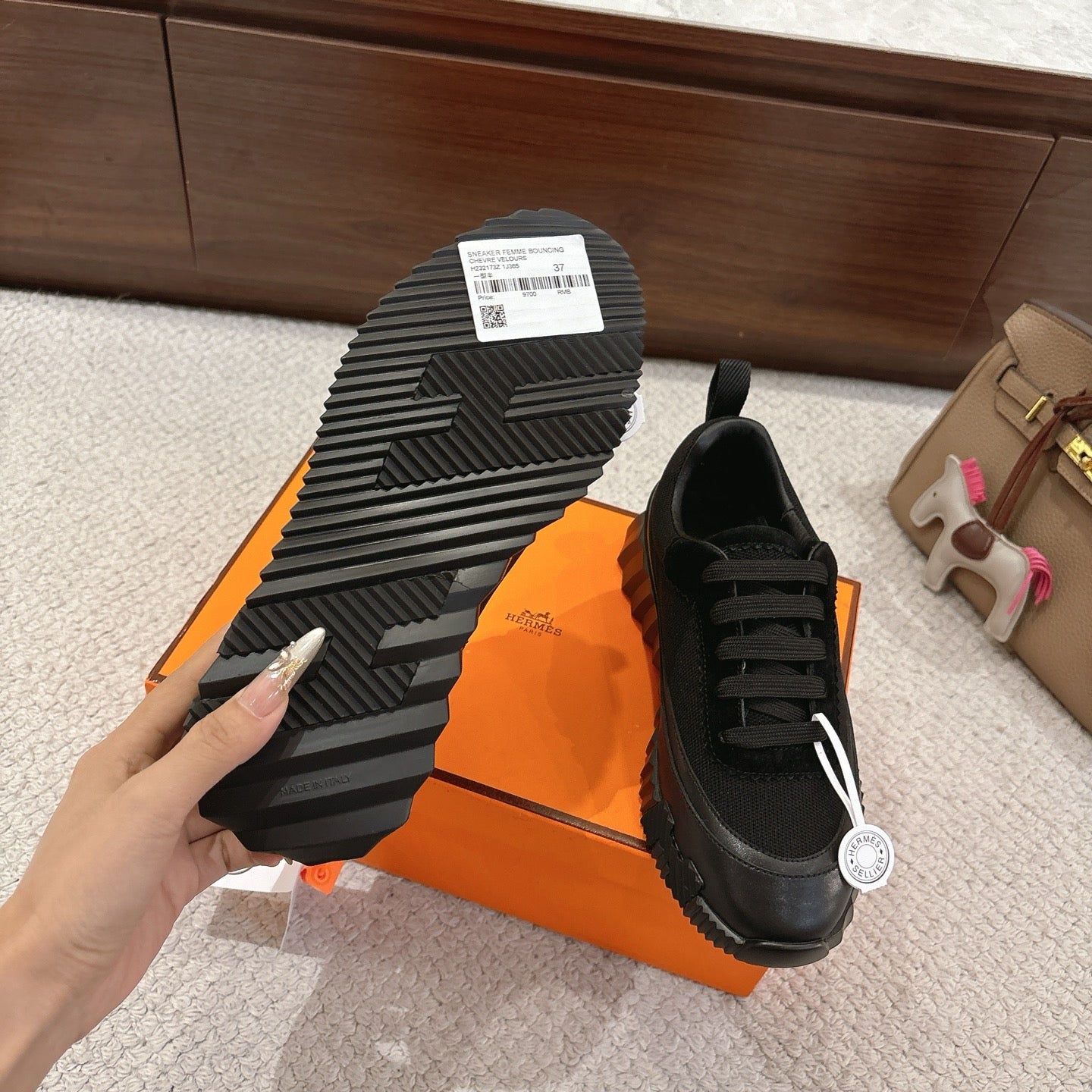 Hermes unisex sneaker outsole and side profile, black shoe with deep tread.