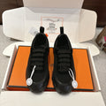 Hermes unisex lace-up sneakers, black with chunky tread sole.