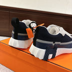 Unisex navy and white sneakers with white laces, rear pull tab, and orange tag