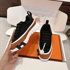 Unisex low-top sneakers, black upper with tan panel, black laces, thick white ridged sole
