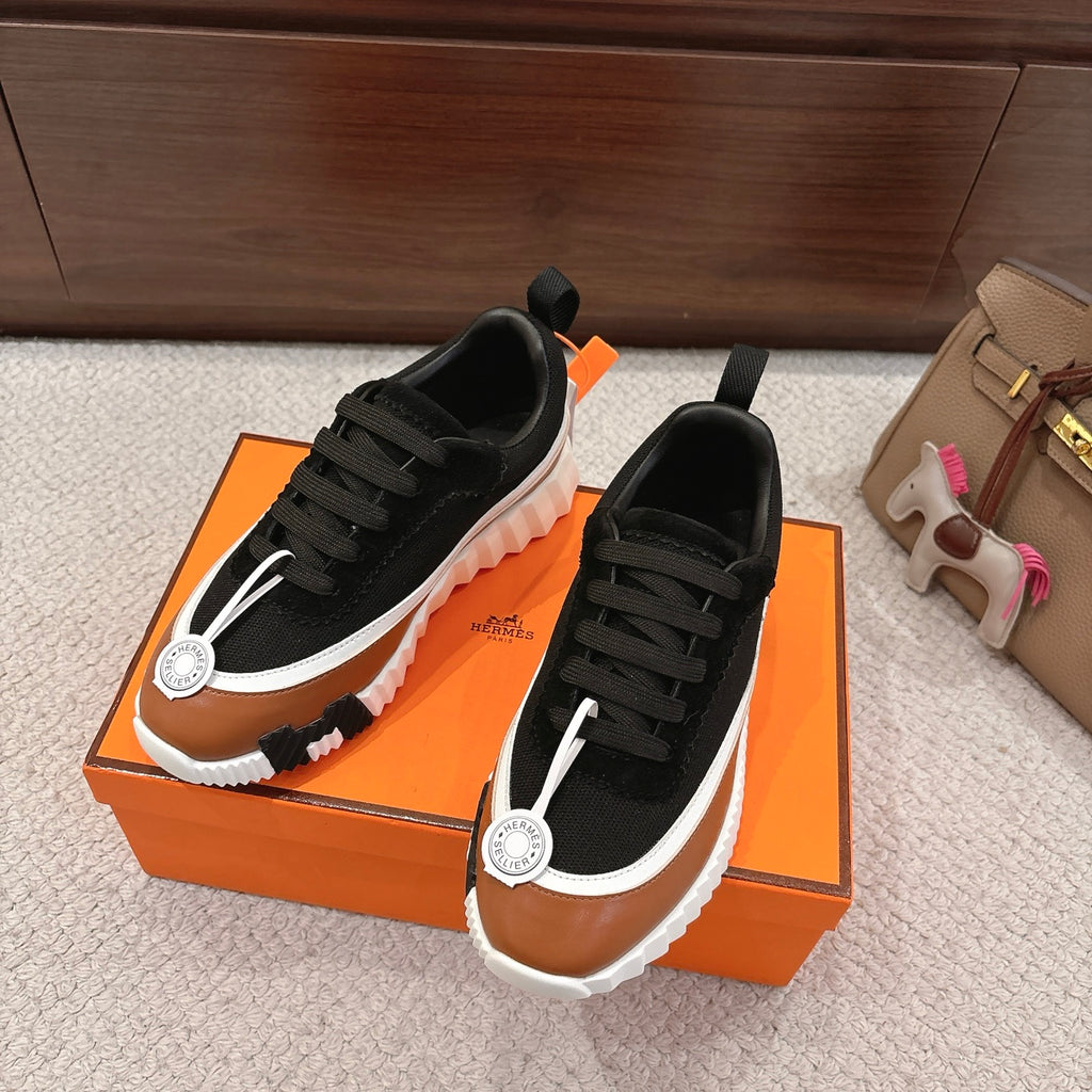 Unisex sneakers pair in black and tan with black lace-up front and white cushioned sole