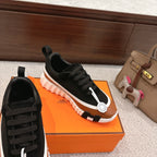 Unisex lace-up sneakers in black with tan accents and white ridged platform sole