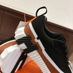 Unisex high-top style sneaker detail with black upper, tan side, and white ridged sole