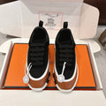Unisex athletic sneakers in black and tan with black laces, white sole, logo badge