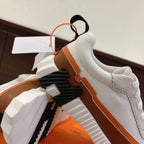 Hermes unisex sneakers side view with brown stripe, white textured upper, raised sole lugs