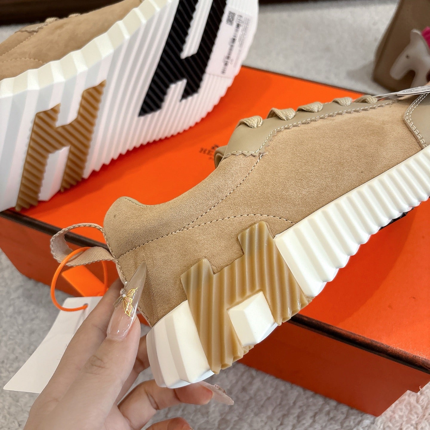 Beige sneaker upper and sole detail with ridged white outsole and stitched seams