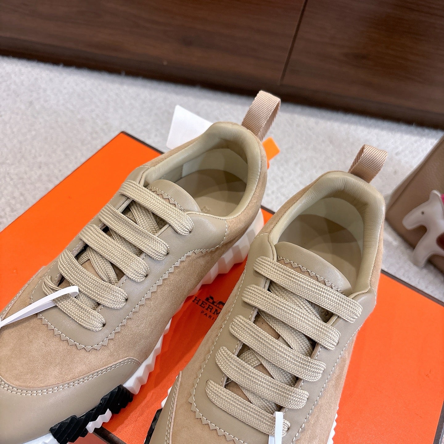 Beige lace-up sneakers with white chunky sole and cushioned collar, angled pair