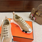 Hermes unisex sneakers in beige with lace-up closure, contrasting dark heel detail, and white sole.