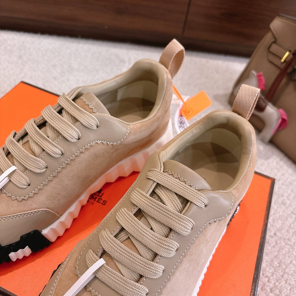 Hermes unisex sneakers pair in beige with lace-up closure and cushioned white tread soles.