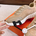 Hermes unisex sneakers side view: beige suede upper, lace-up, and thick white tread sole.